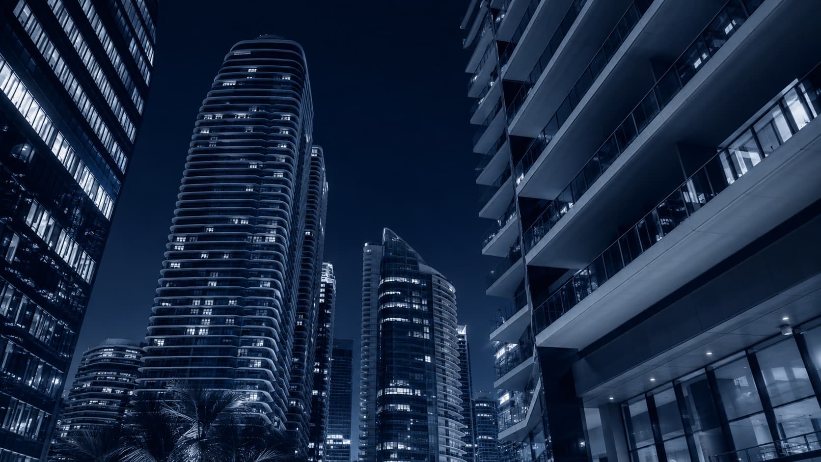 Street-level view of residential and retail towers at night